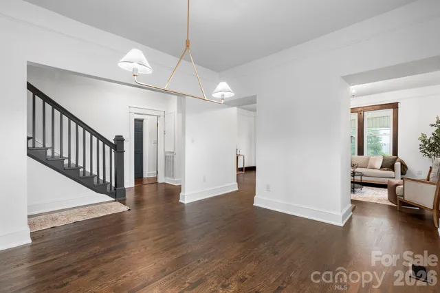a view of a livingroom with wooden floor and a ceiling fan