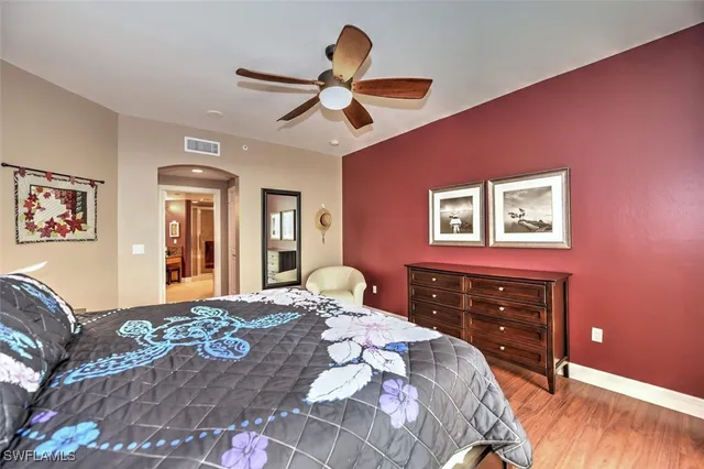 a bedroom with a large bed and a chandelier