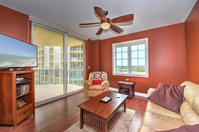 a living room with furniture a flat screen tv and a large window