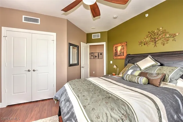 a bedroom with a bed and a painting on the wall