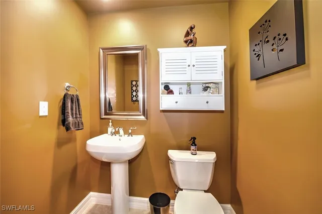 a bathroom with a sink mirror and toilet
