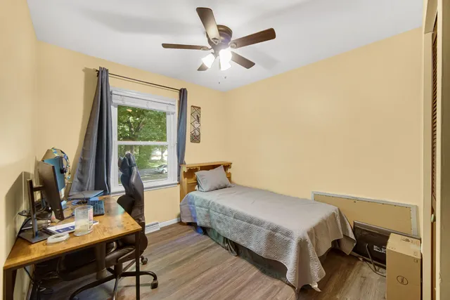 a bedroom with a bed table and a desk