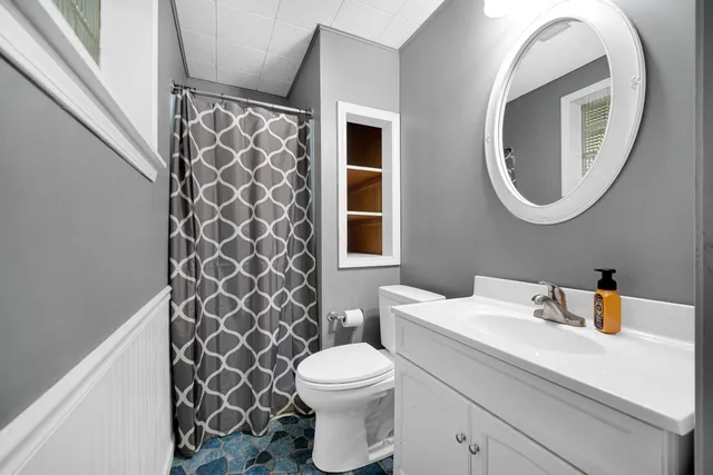 a bathroom with a sink a toilet and a mirror