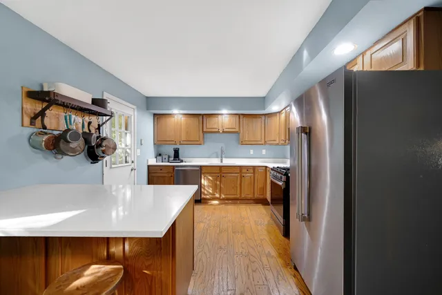 a kitchen with stainless steel appliances granite countertop a sink a stove and a refrigerator