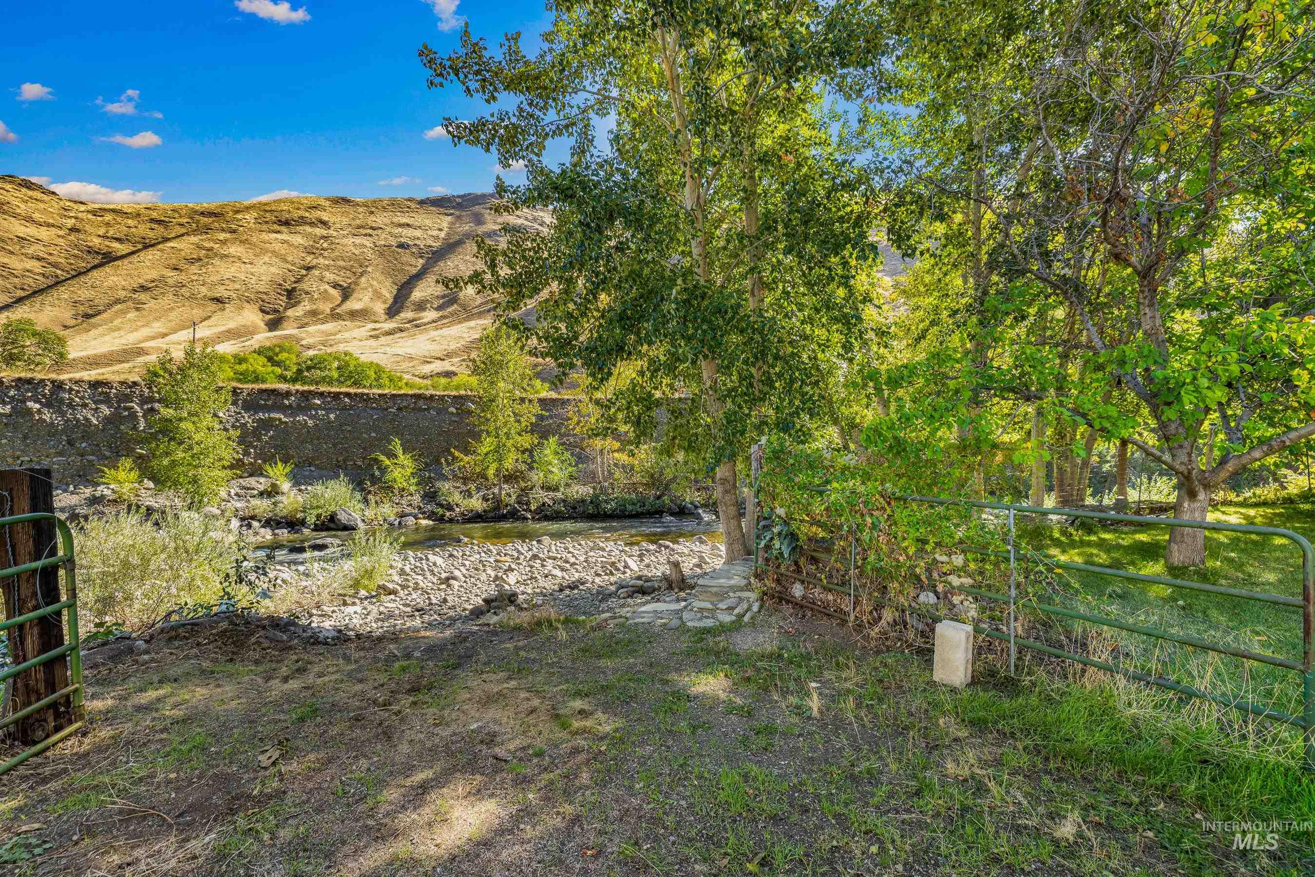 7026 S Highway Riggins, ID 83549 - Photo 45 of 50 Red metal roof, extensive green landscaping, detached outbuilding, greenhouse, mountainous backdrop