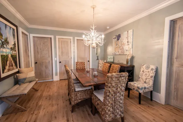 a dining room with furniture a chandelier and wooden floor