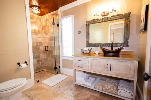 a bathroom with a granite countertop toilet a sink and a mirror