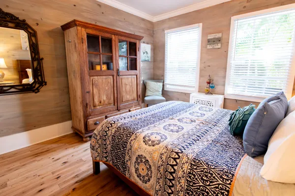 a bedroom with a bed and wooden floor