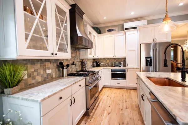 a kitchen with stainless steel appliances granite countertop a sink a stove and a refrigerator