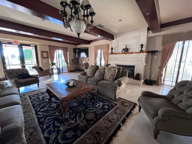 a living room with furniture a fireplace and a chandelier