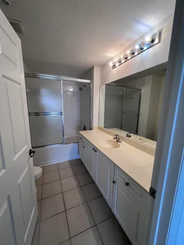 a bathroom with a sink a large mirror and a shower