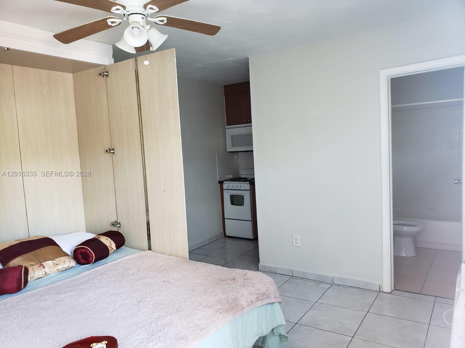 554 Northeast 68th Street, Unit 4 Miami, FL 33138 - Photo 14 of 15 a bedroom with a bed and a chandelier