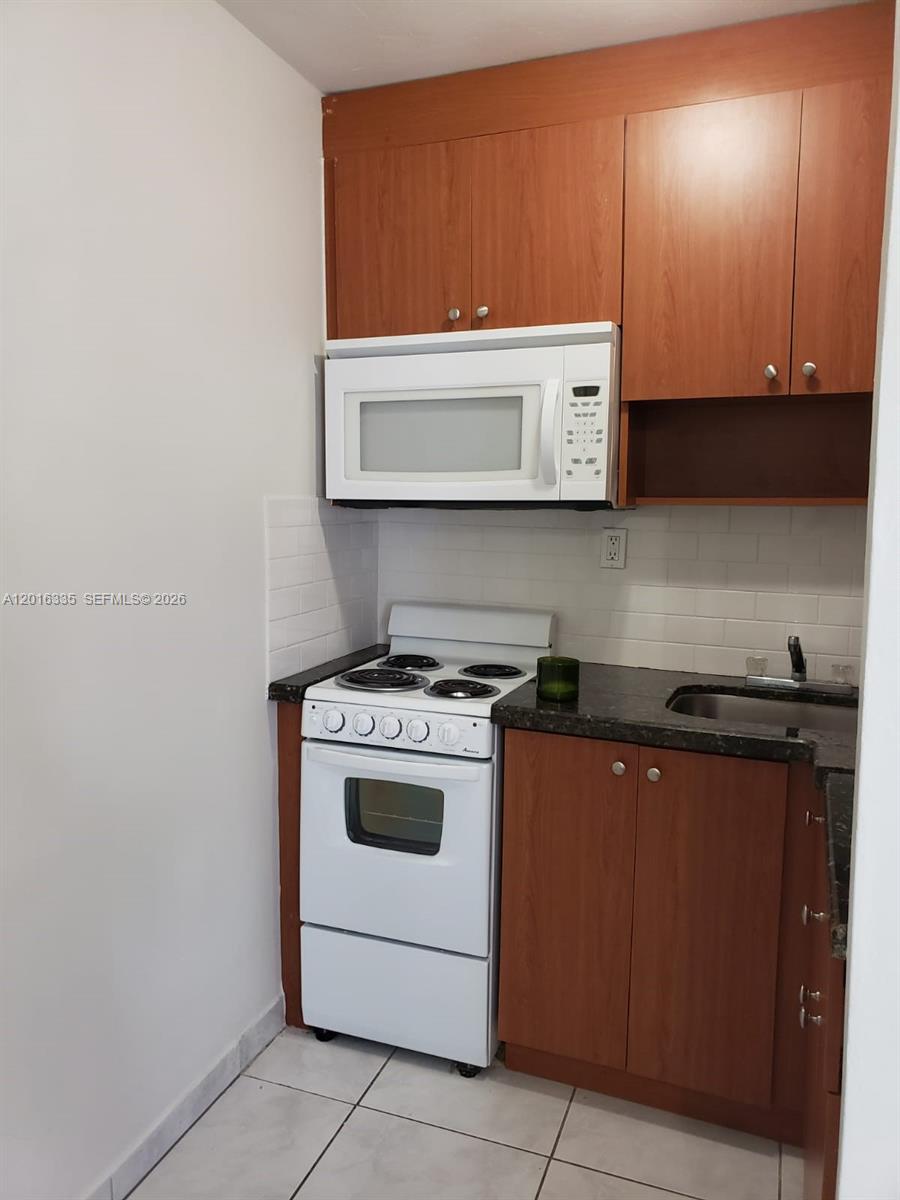 554 Northeast 68th Street, Unit 4 Miami, FL 33138 - Photo 2 of 15 a kitchen with a stove and a microwave
