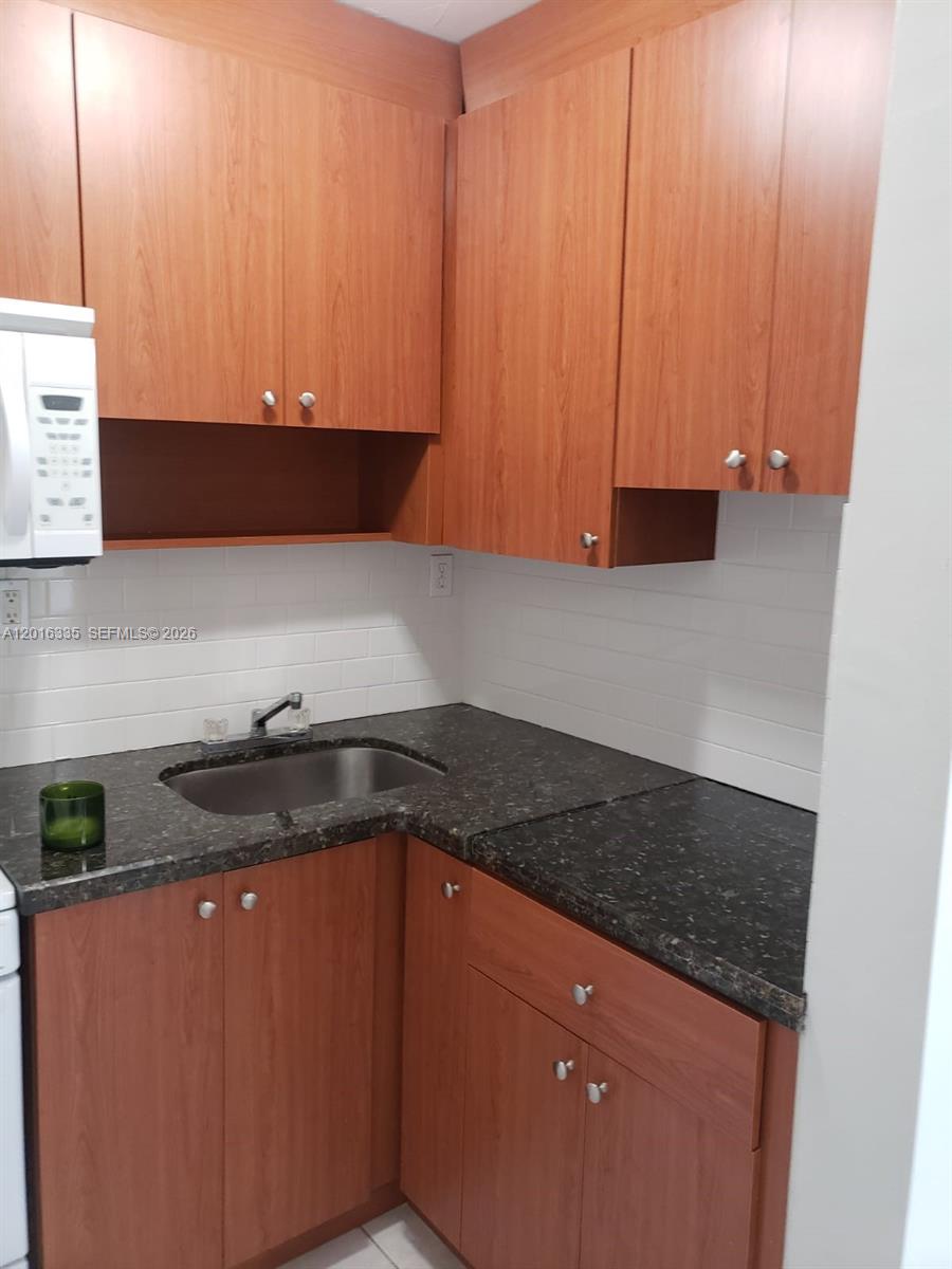 554 Northeast 68th Street, Unit 4 Miami, FL 33138 - Photo 3 of 15 a kitchen with granite countertop cabinets and a sink