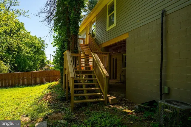 a view of a house with backyard and wooden fence