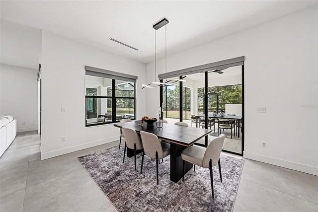 a dining room with furniture a chandelier and wooden floor