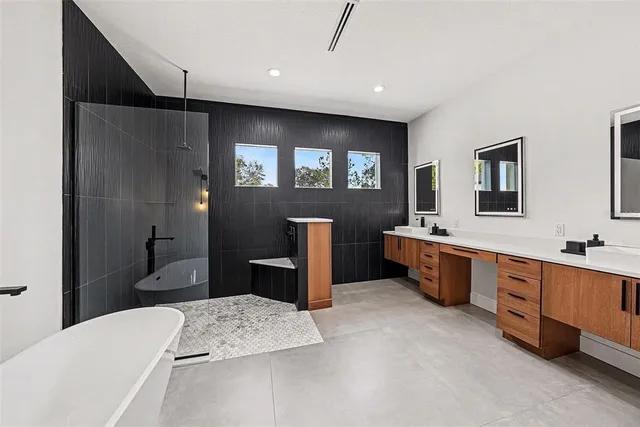 a bathroom with a tub sink a mirror and a shower