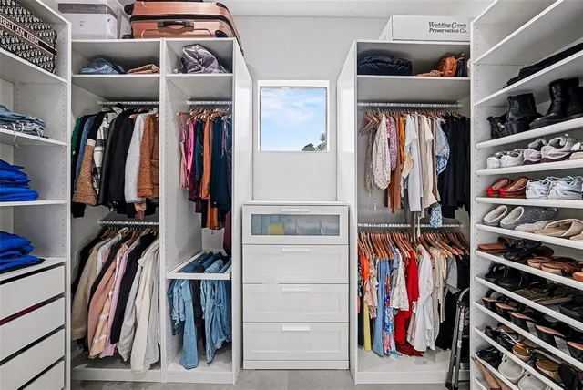 a view of walk in closet with clothes and shoes