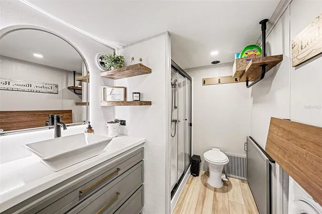 a view of a kitchen with stainless steel appliances wooden floor and large windows
