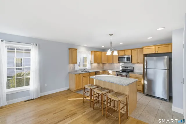 a kitchen with a table chairs refrigerator and microwave