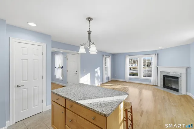 a kitchen with stainless steel appliances granite countertop a kitchen island a stove and a wooden cabinets