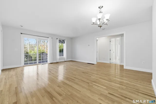 a view of a livingroom with wooden floor and a large window