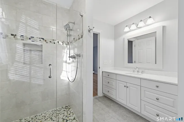 a bathroom with a double vanity sink mirror and shower