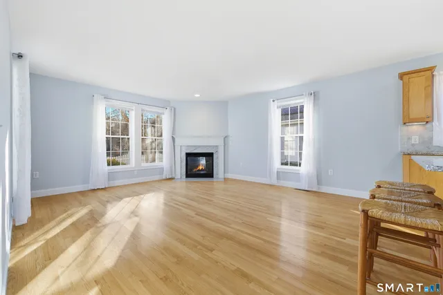 a view of empty room with wooden floor and fireplace
