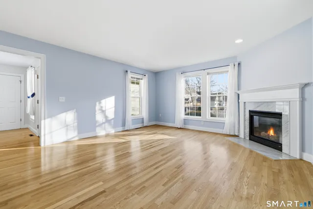 a view of an empty room with a window and fireplace