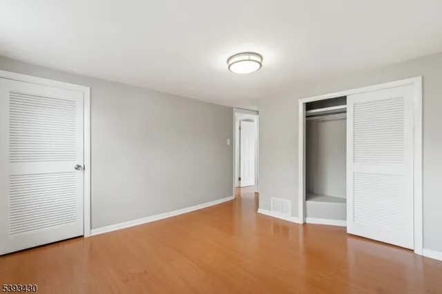 an empty room with wooden floor and closet
