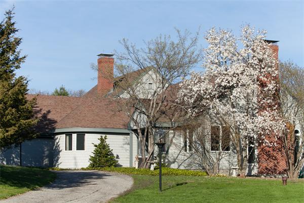 a view of a white house next to a yard