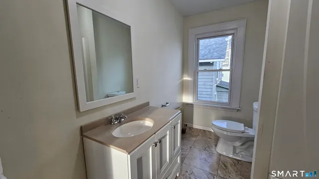 a bathroom with a sink toilet and mirror