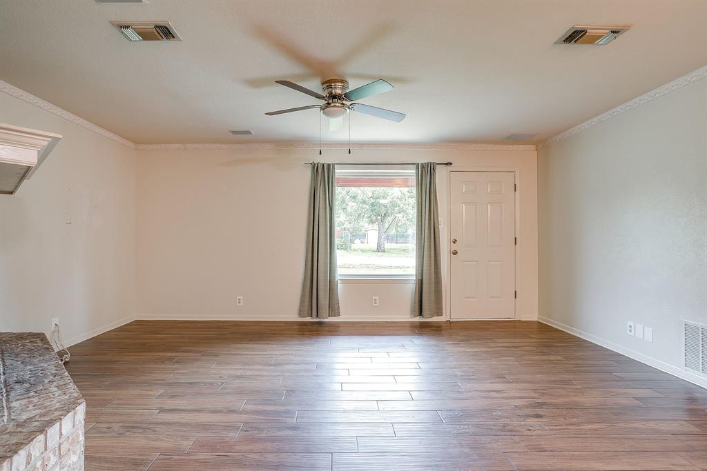 709 North Ave B Springtown, TX 76082 - Photo 9 of 32 a view of an empty room with wooden floor and a window