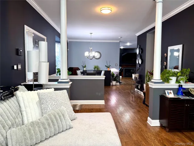 a living room with furniture a large window and wooden floors