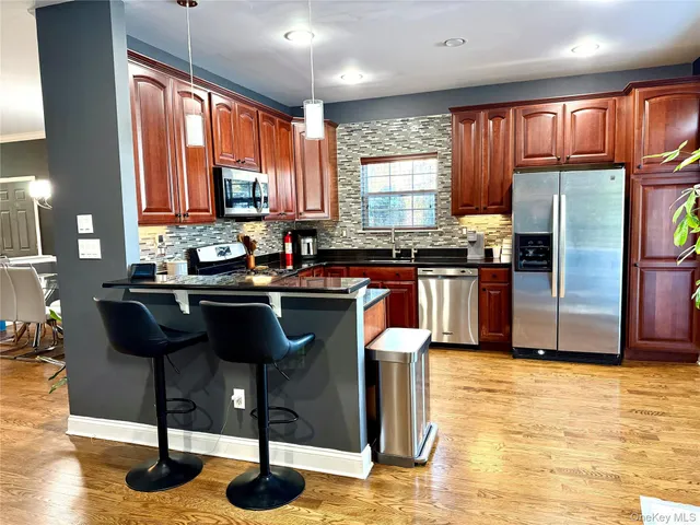 a kitchen with granite countertop a sink stainless steel appliances and cabinets