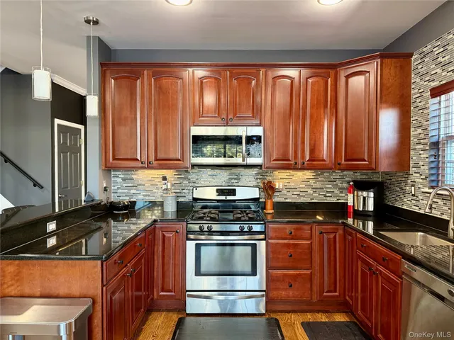 a kitchen with stainless steel appliances a stove sink microwave and cabinets