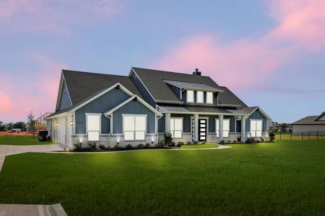 a front view of a house with a garden and trees