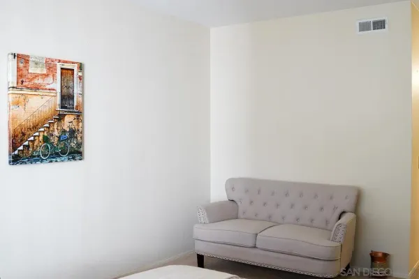 a living room with furniture and a wall painting