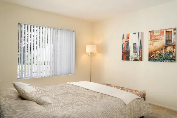 a bedroom with a bed and a large window