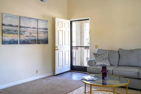 a living room with furniture and a floor to ceiling window