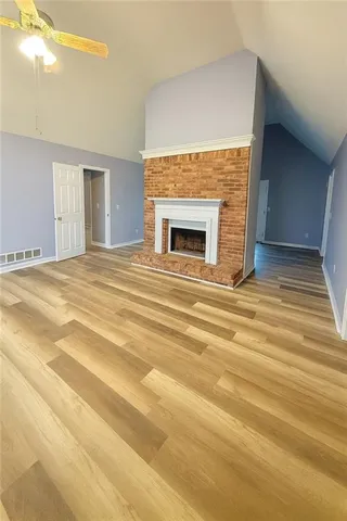 a view of empty room with wooden floor and fireplace