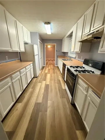 a kitchen with stove a sink and a refrigerator