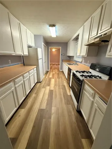 a view of a kitchen with a sink and wooden floor