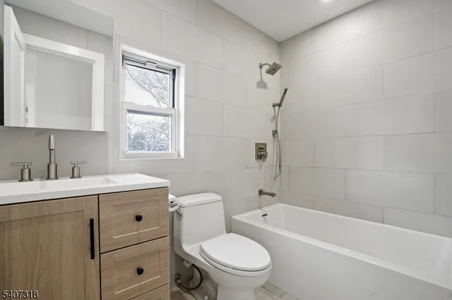 a kitchen with stainless steel appliances granite countertop a stove a refrigerator a microwave a dining table and chairs with wooden floor