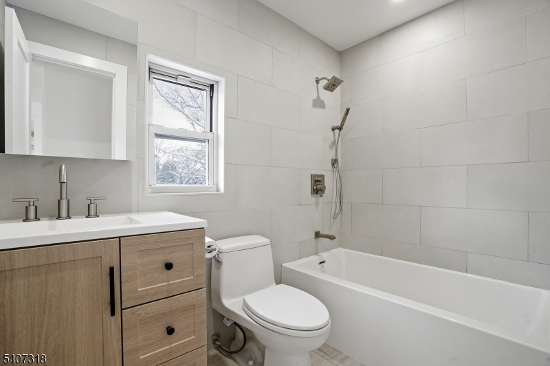 554 Hort Street Westfield, NJ 07090 - Photo 3 of 19 a bathroom with a toilet sink vanity tub and mirror