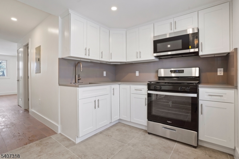 554 Hort Street Westfield, NJ 07090 - Photo 8 of 19 a kitchen with white cabinets and stainless steel appliances
