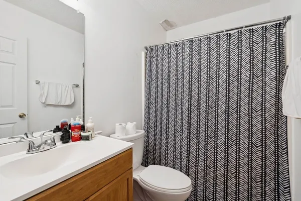 a bathroom with a sink vanity mirror and toilet