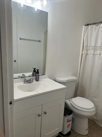 a bathroom with a sink a toilet a mirror and shower