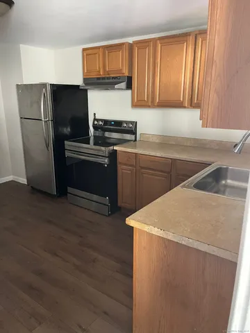 a kitchen with a refrigerator sink and cabinets