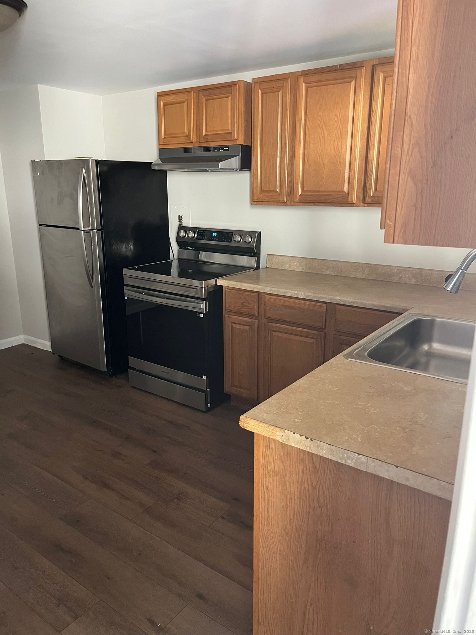a kitchen with a refrigerator sink and cabinets